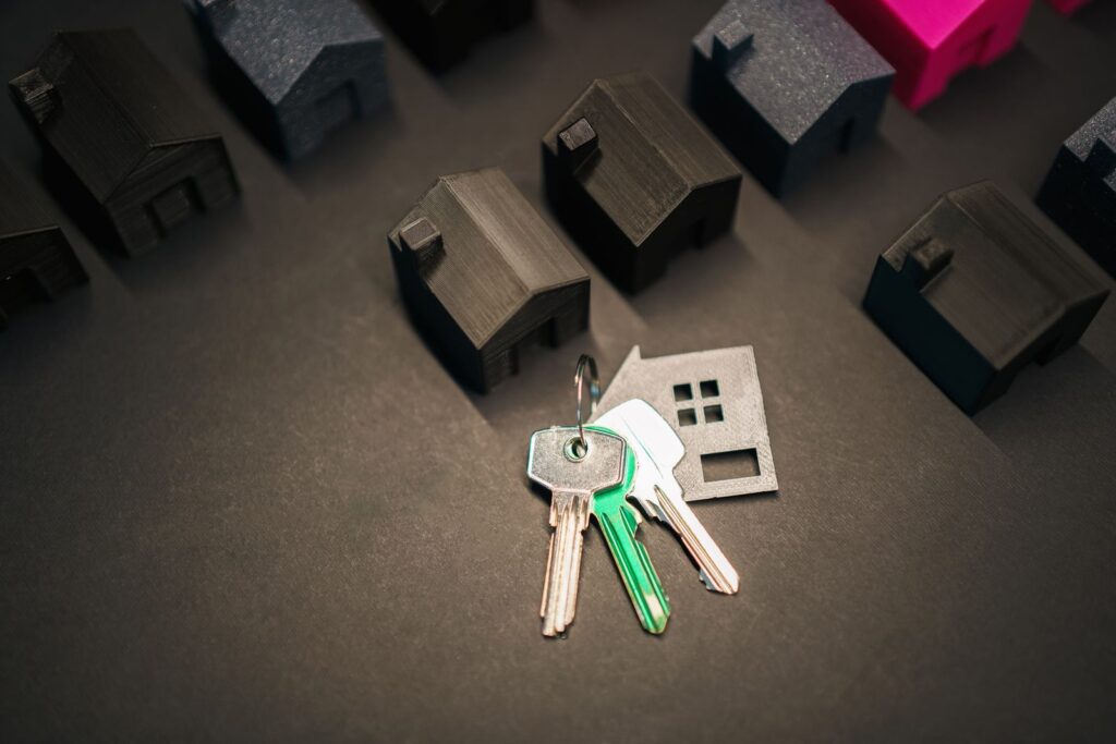 Chaves com chaveiro em formato de casa ao lado de miniaturas de casas, representando financiamento imobiliário