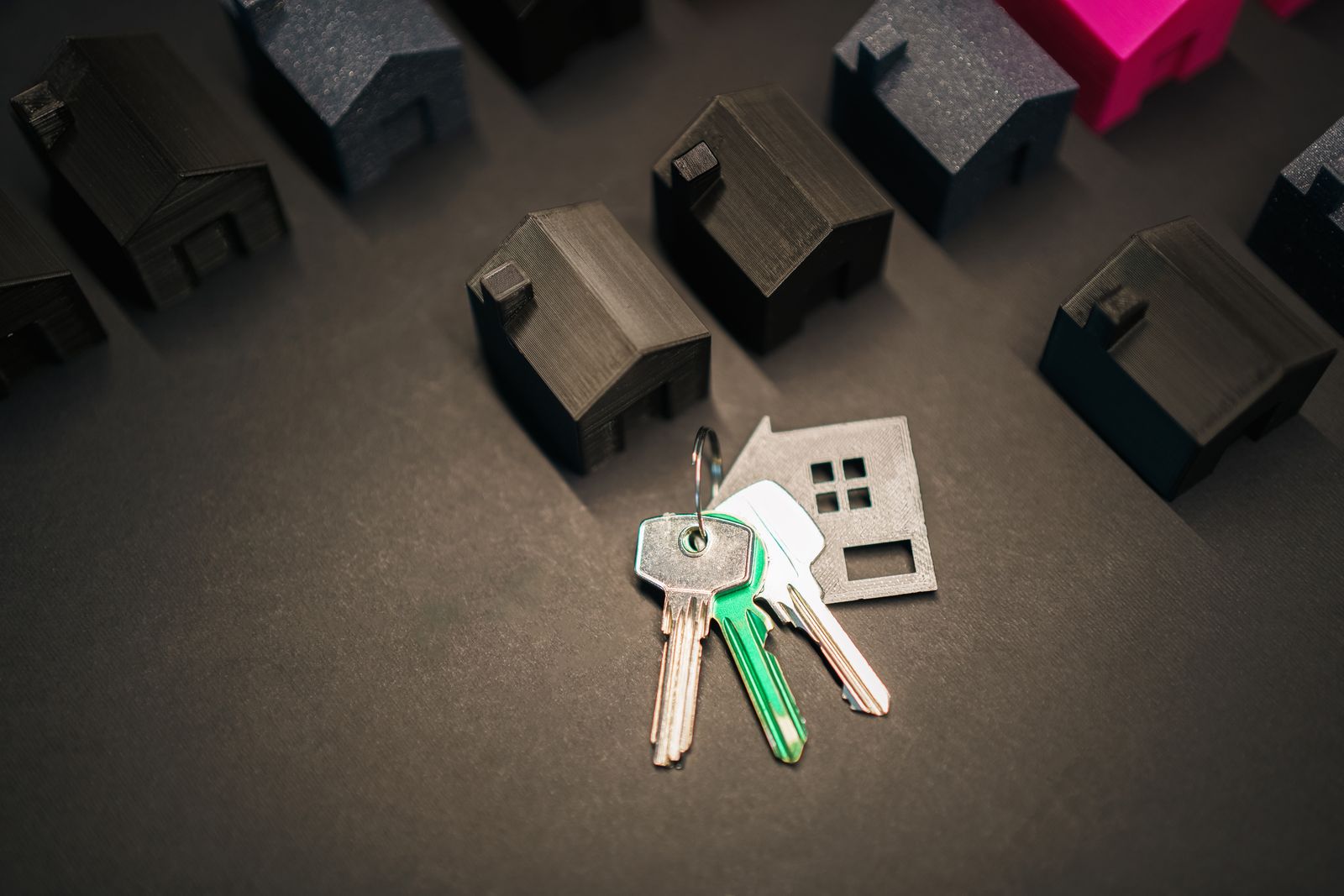 Chaves com chaveiro em formato de casa ao lado de miniaturas de casas, representando financiamento imobiliário